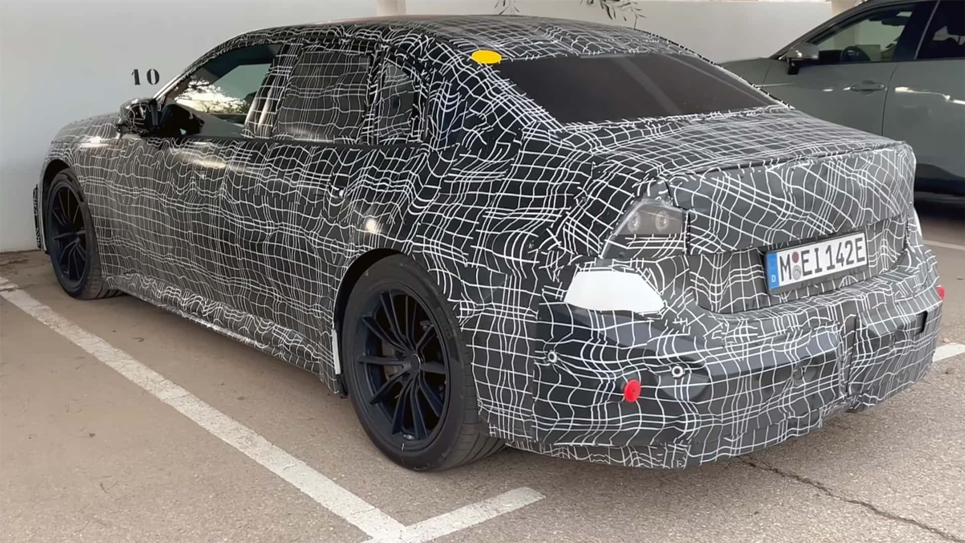 Tesla prototype bil med camouflage på parkeringsplads