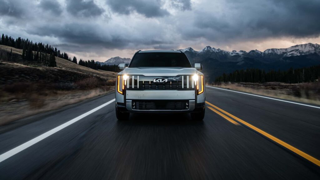 Elektrisk SUV kører på naturskøn vej med bjerge i baggrunden