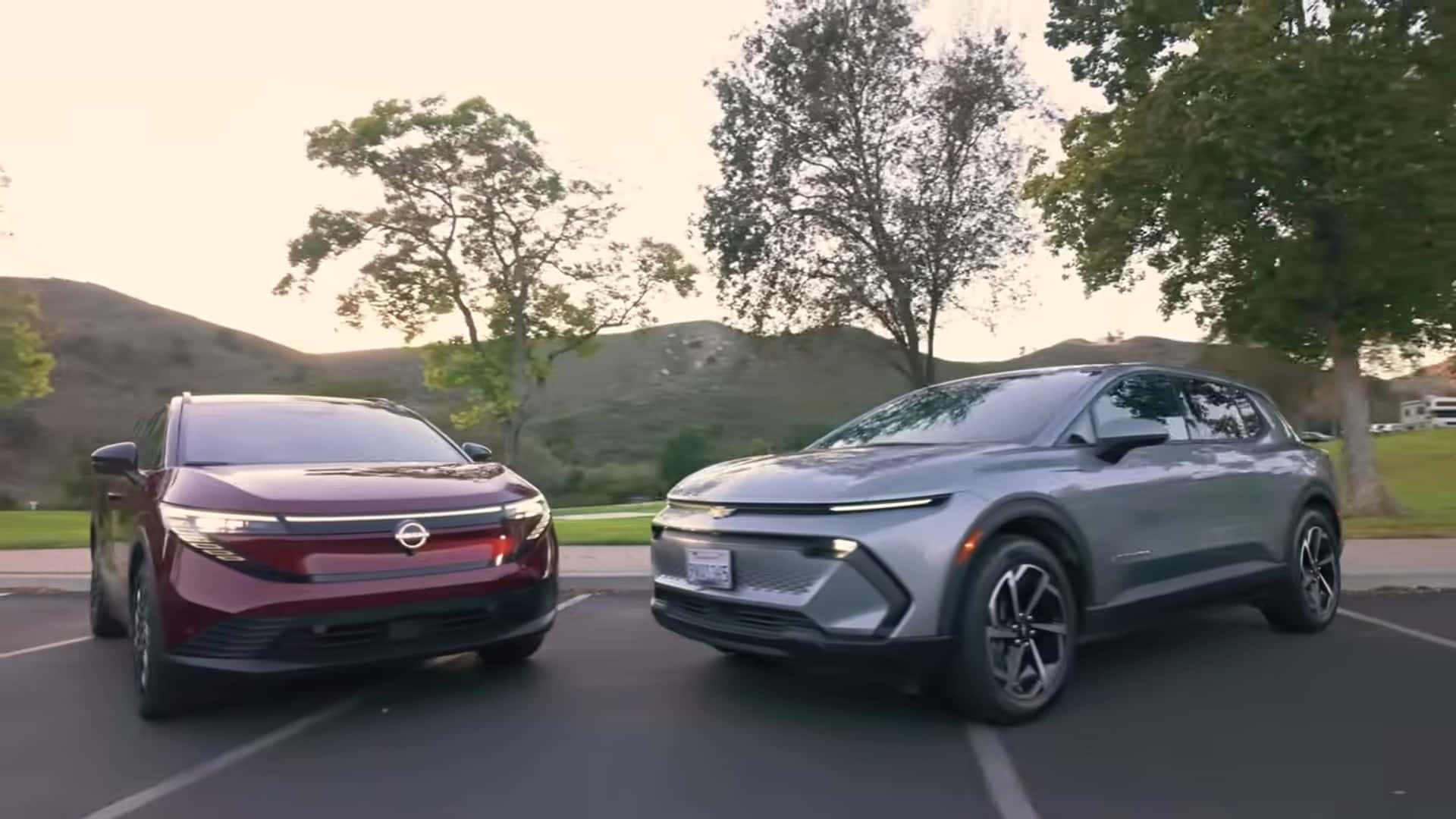 To moderne elbiler parkeret i en naturskøn park