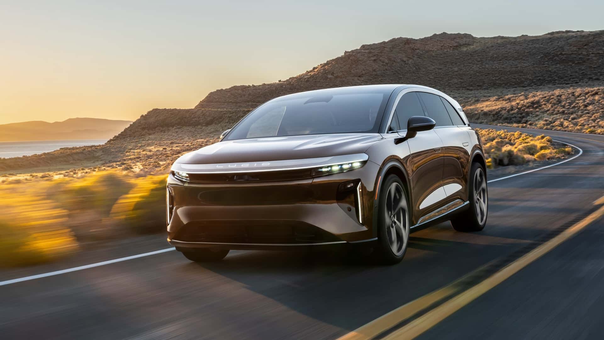 Elegant elektrisk bil på en landevej ved solnedgang