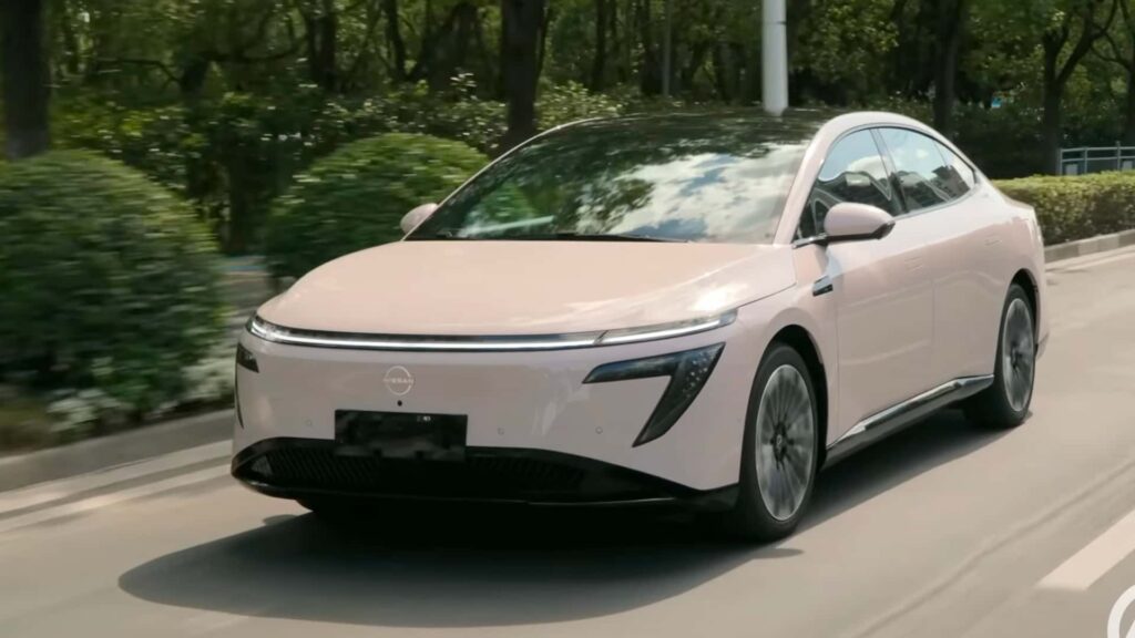 Elektrisk bil kører på vejen omgivet af grønne træer, moderne design og avanceret teknologi.