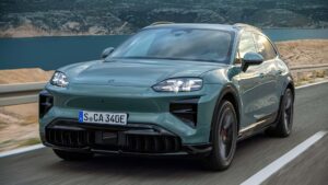 Moderne elektrisk SUV kører på landevej med naturskønt baggrund i Danmark