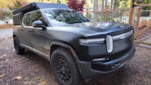 Robust elektrisk pickup truck i skovklædt område, ideel til teknologi- og bilentusiaster