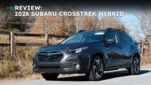 Anmeldelse af 2026 Subaru Crosstrek Hybrid foran en trægærde med efterårsfarver i baggrunden.