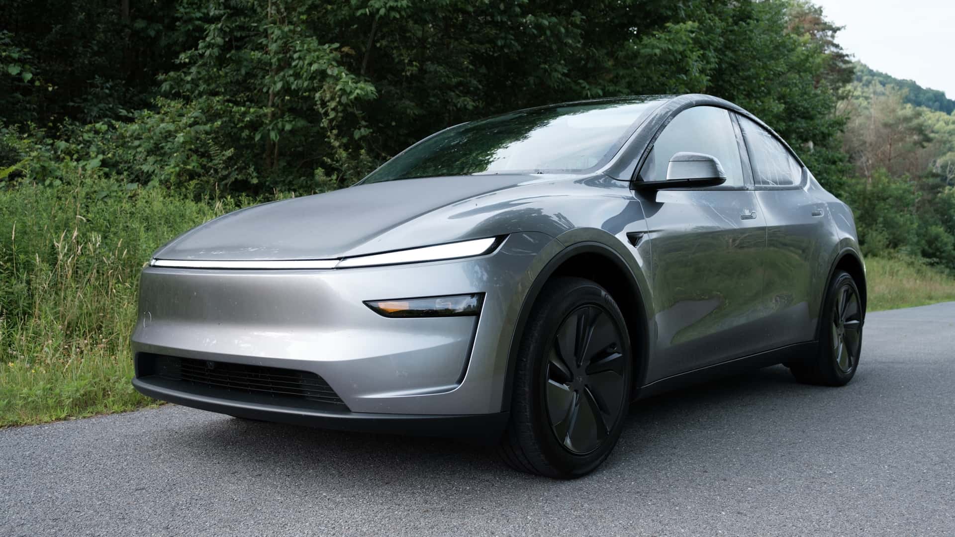 Futuristisk elektrisk bil parkeret i en naturskøn skovområde