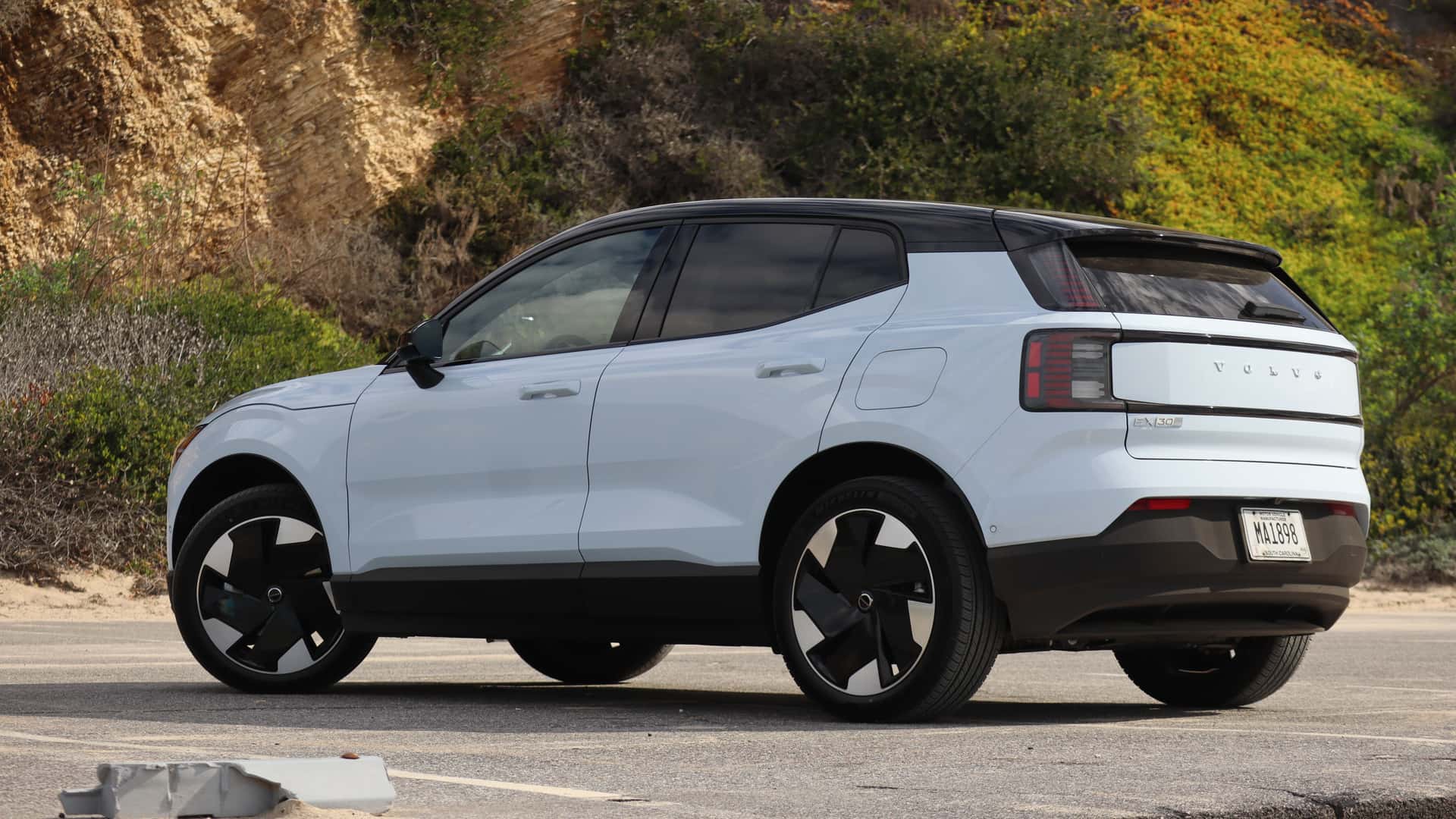 Hvid elektrisk SUV parkeret foran en klippevæg