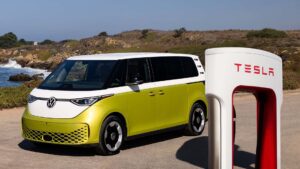 VW ID.Buzz parkeret ved Tesla ladestation langs kysten