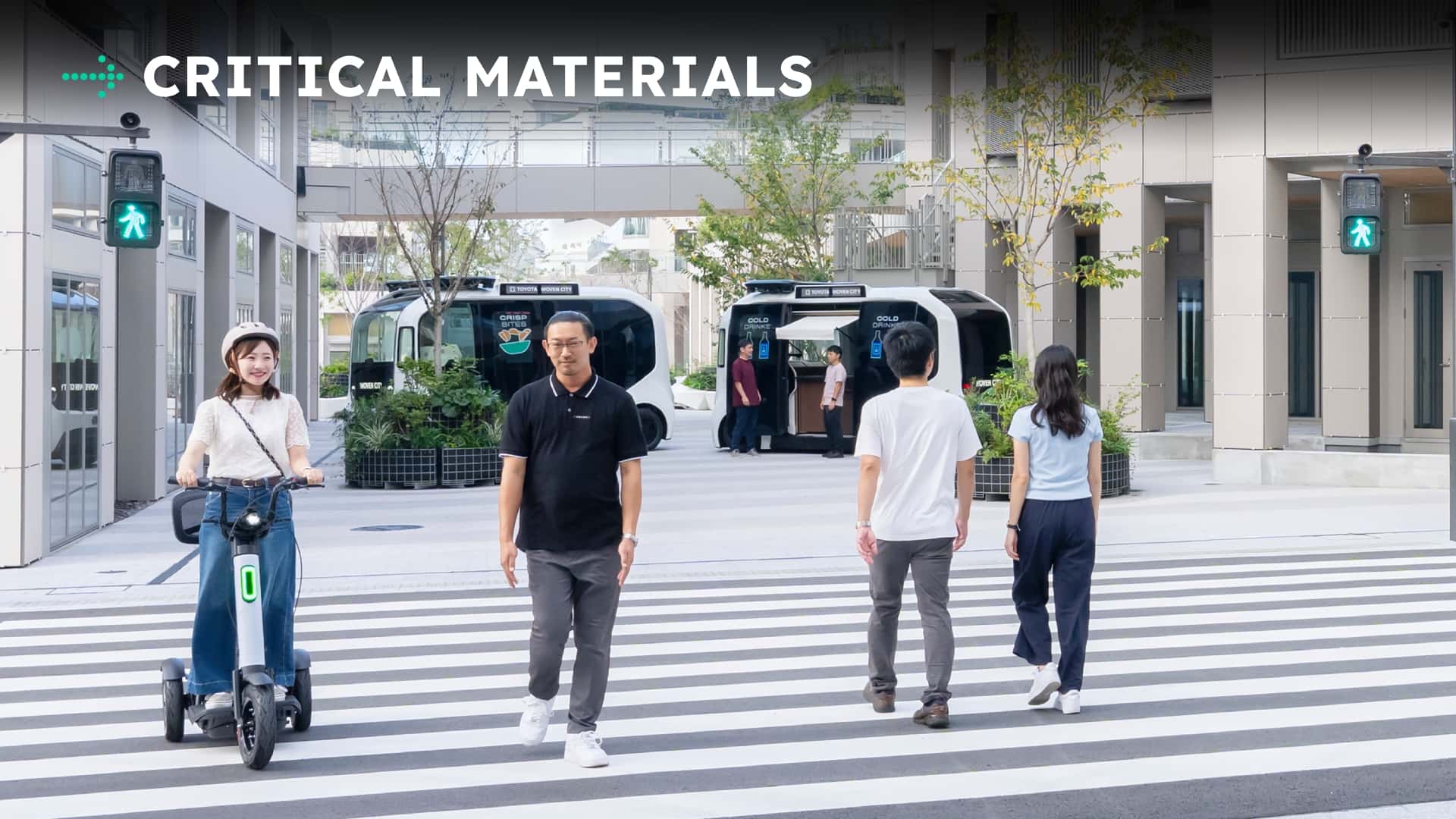 Personer der krydser vejen ved elektriske køretøjer i moderne bymiljø