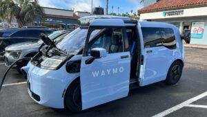 Autonom elbil fra Waymo oplades i solrig bymiljø