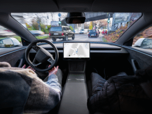 Person kører en Tesla med autopilotfunktionen aktiveret i en by.