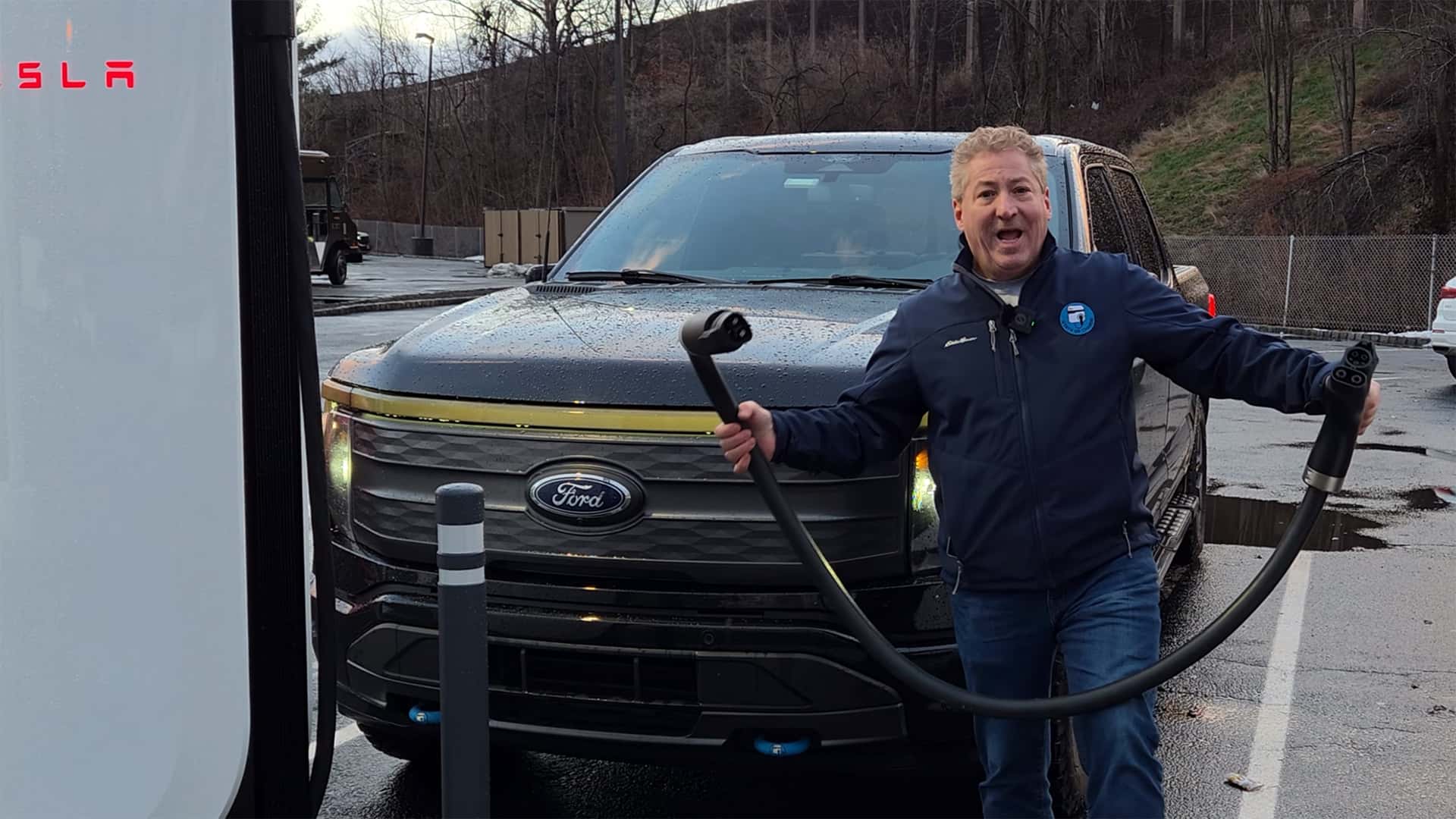 Mand ved en Tesla-ladestation med en elektrisk pickup-truck