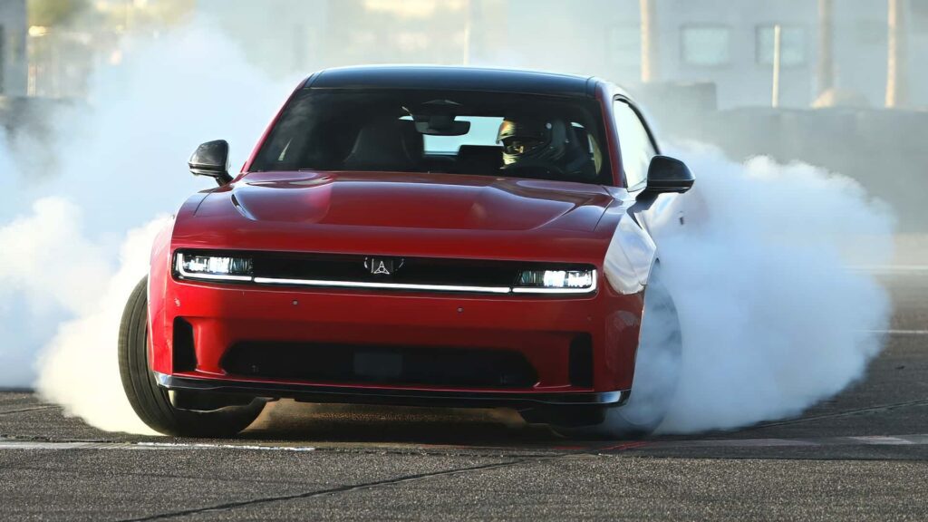 Rød sportsvogn udfører et drift med røg fra dækkene