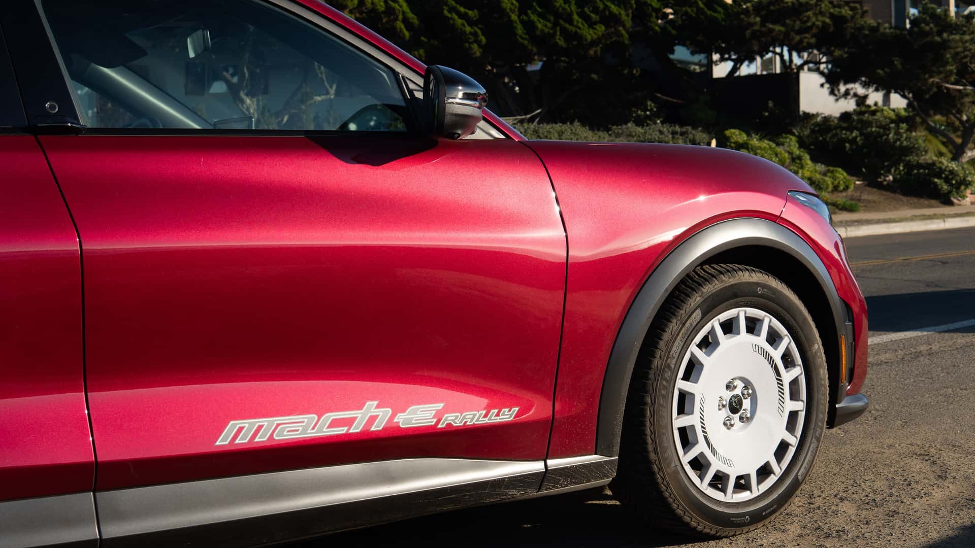 Rød elektrisk bil med Mach-E Rally-logo på siden, set fra siden