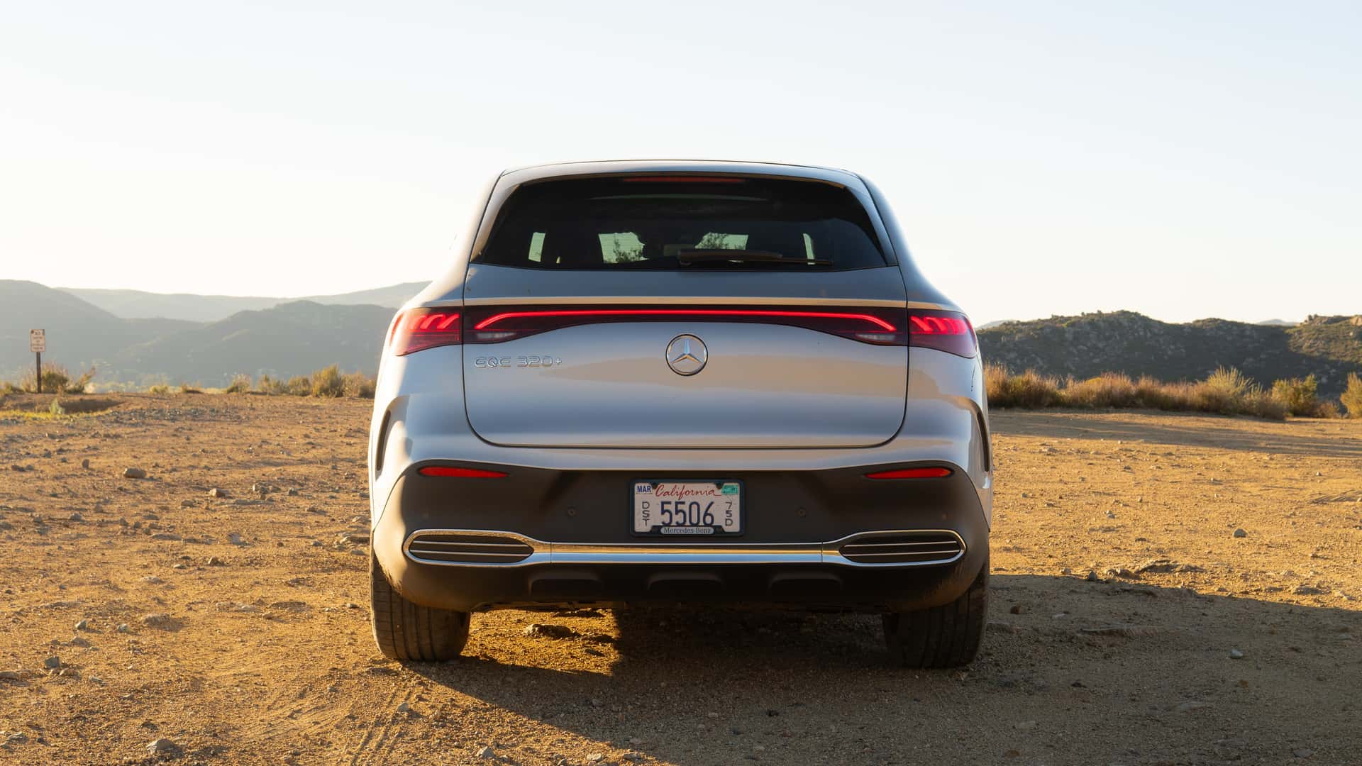 Bagenden af en Mercedes EQE 350+ elbil parkeret i et ørkenlandskab