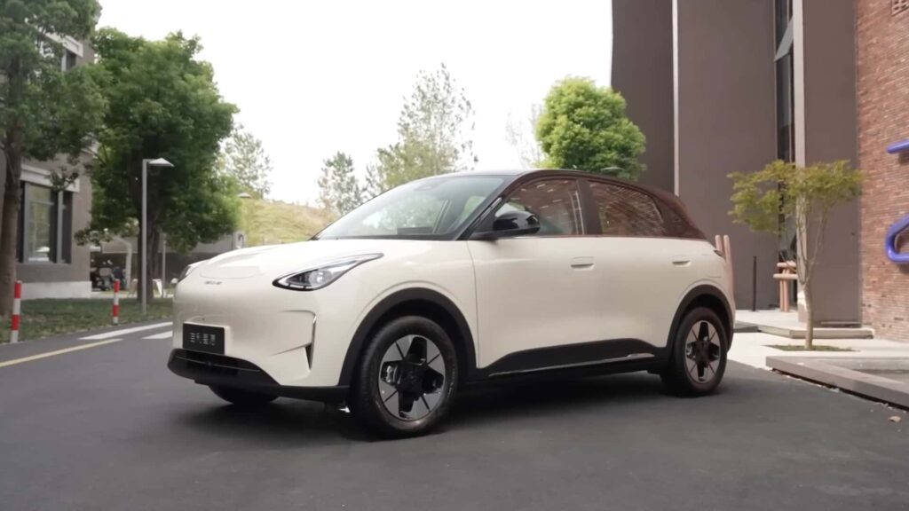 Elektrisk SUV parkeret i bymiljø foran moderne bygninger, klar til fremtidens kørsel.