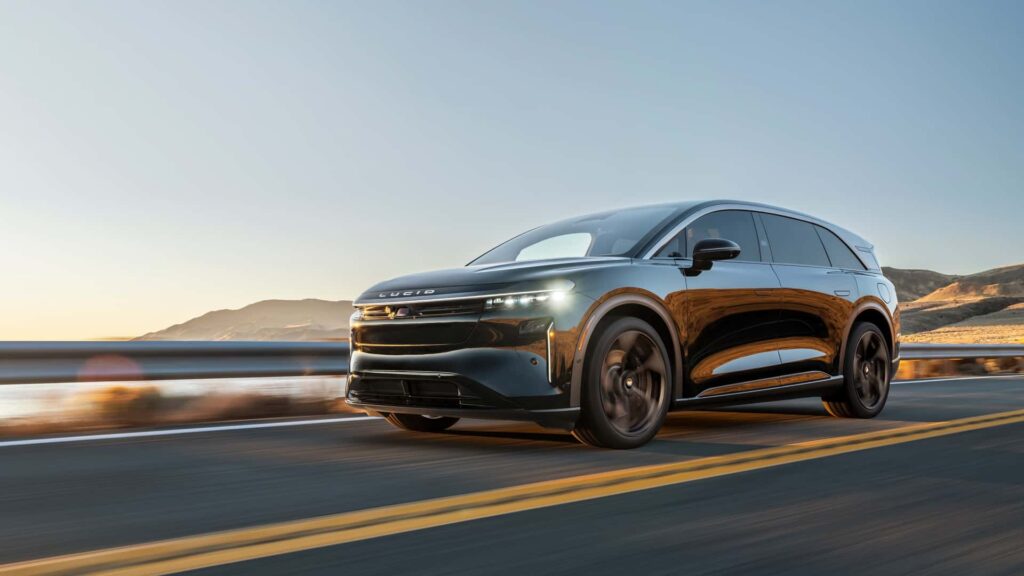 Elektrisk SUV kører på en landevej ved solopgang