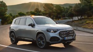 Moderne elektrisk SUV kører på en solrig vej omringet af natur