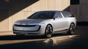 Futuristisk elbil i moderne design parkeret foran en bygning med sollys og skygger