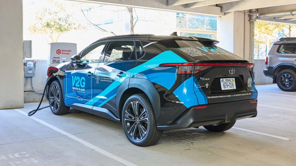 En elbil tilkoblet en ladestation i en parkeringskælder, med V2G-funktionalitet vist på siden