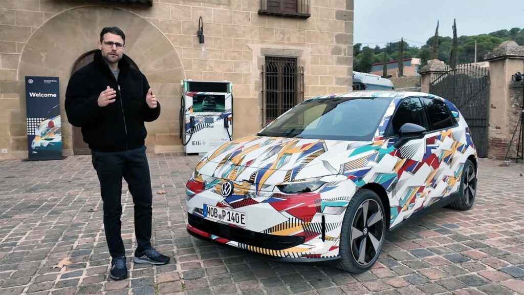 Mand står ved siden af en Volkswagen elbil med farverigt design på gårdsplads