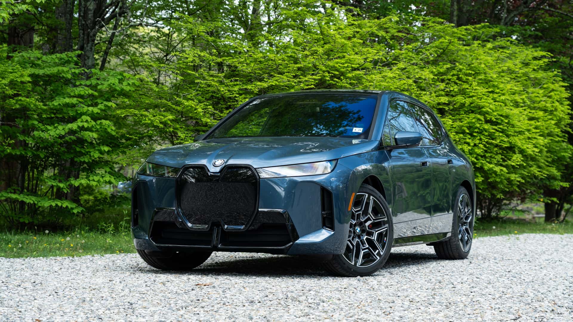 Elektrisk SUV på grusvej omgivet af grøn natur