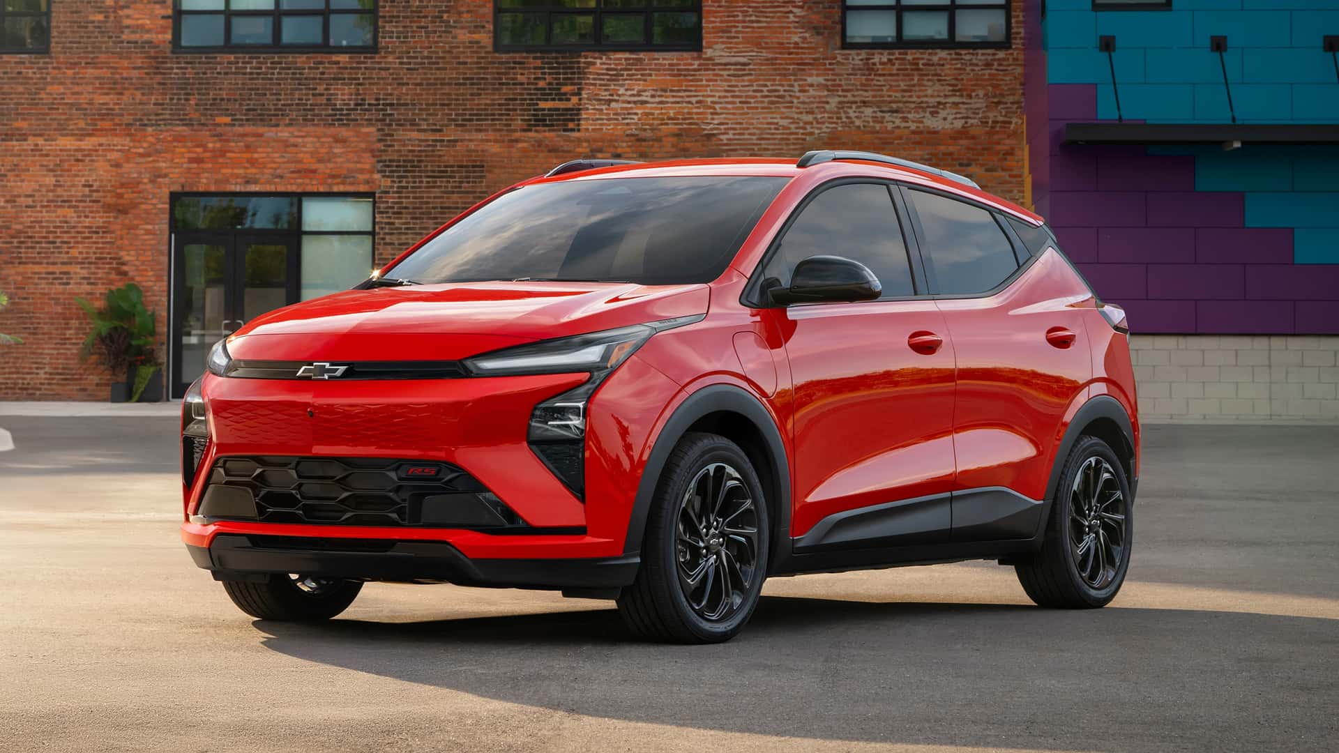 Rød elbil foran murstensbygning, ideel for elbil-entusiaster