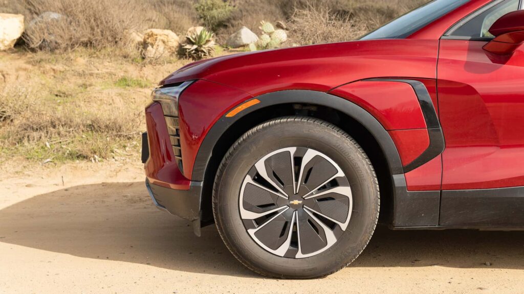 Forhjul af rød elektrisk bil på grusvej