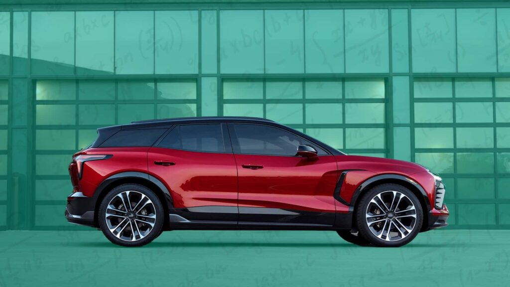 Rød elbil parket foran en grøn glasvæg