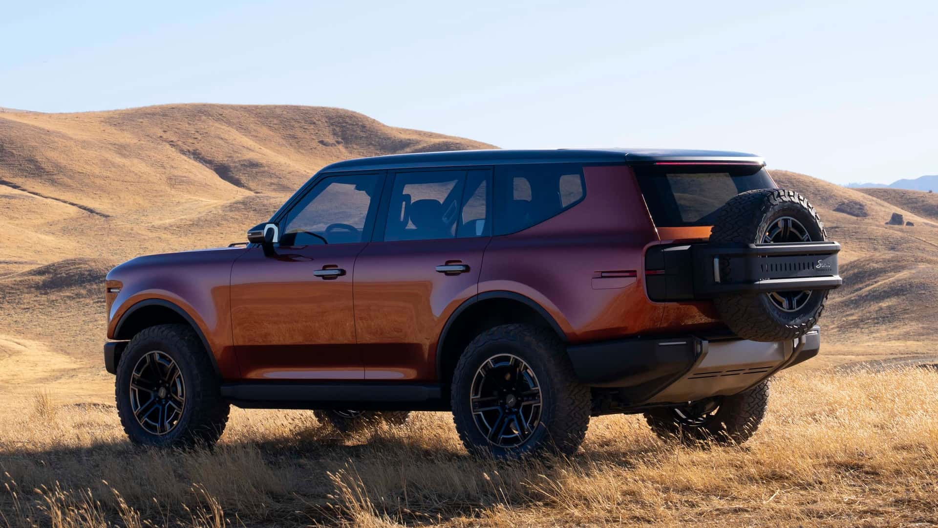 Elbil i øde landskab med bjerge i baggrunden