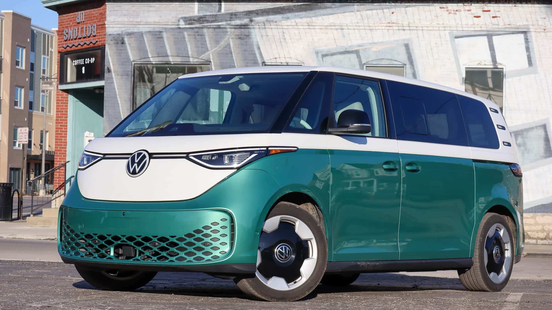 Grøn og hvid elektrisk minibus på gaden