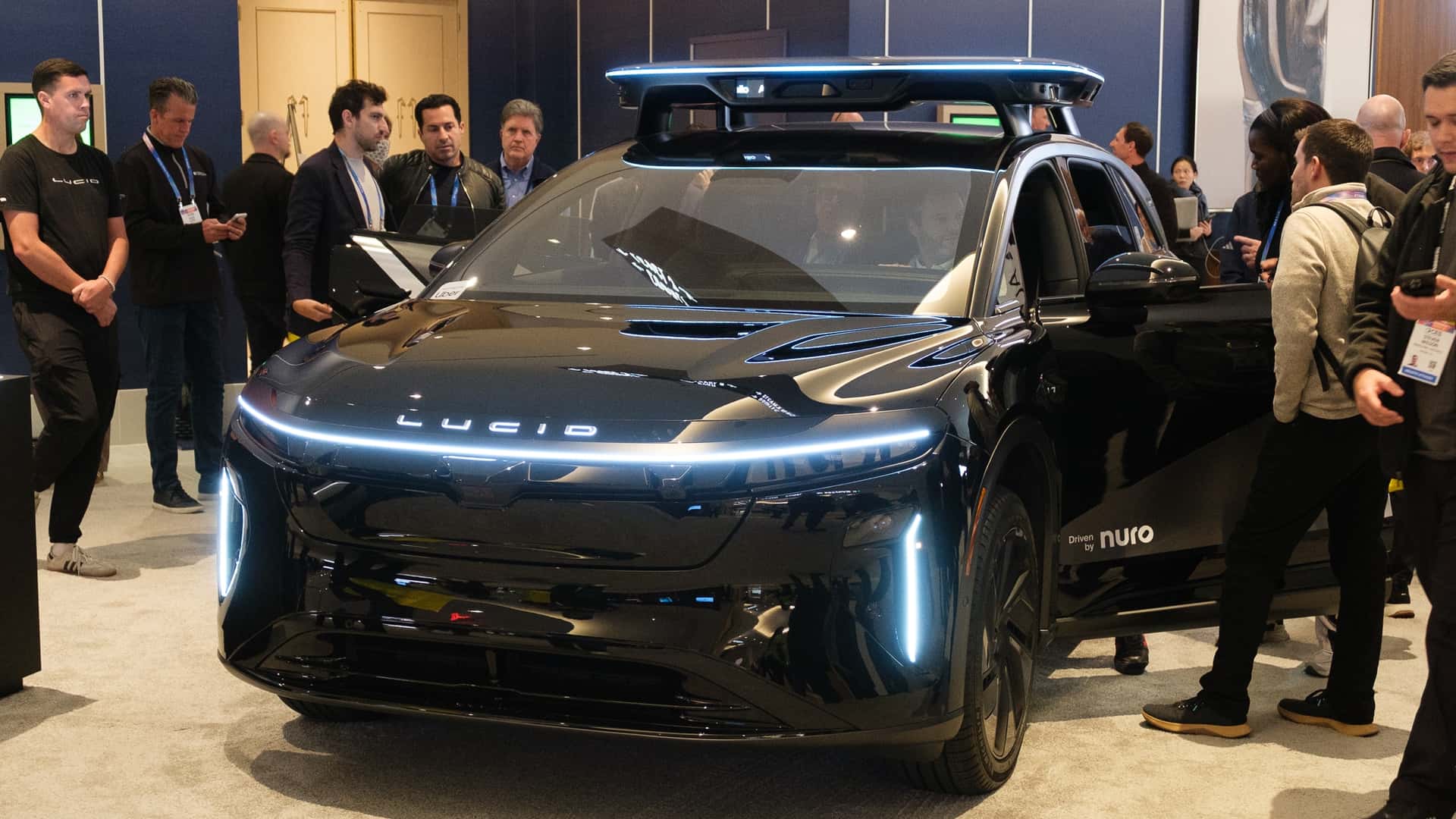 Elektrisk Lucid bil fremvist ved en teknologiudstilling med interesserede tilskuere