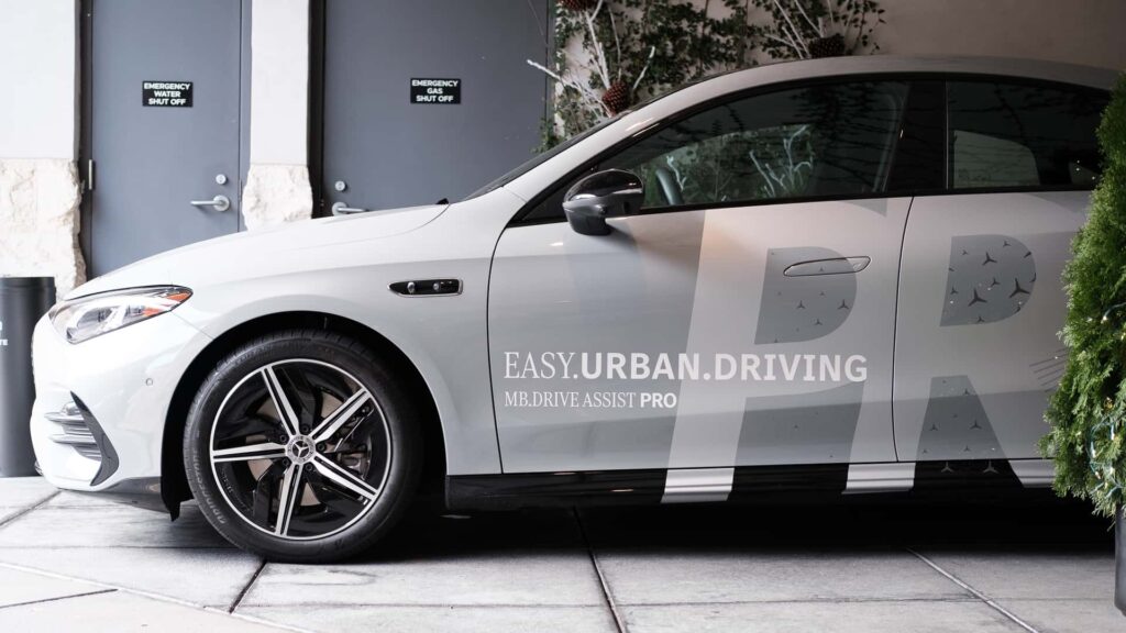 Moderne elbil med slogans for nem bykørsel på siden, parkeret ved nødudgang