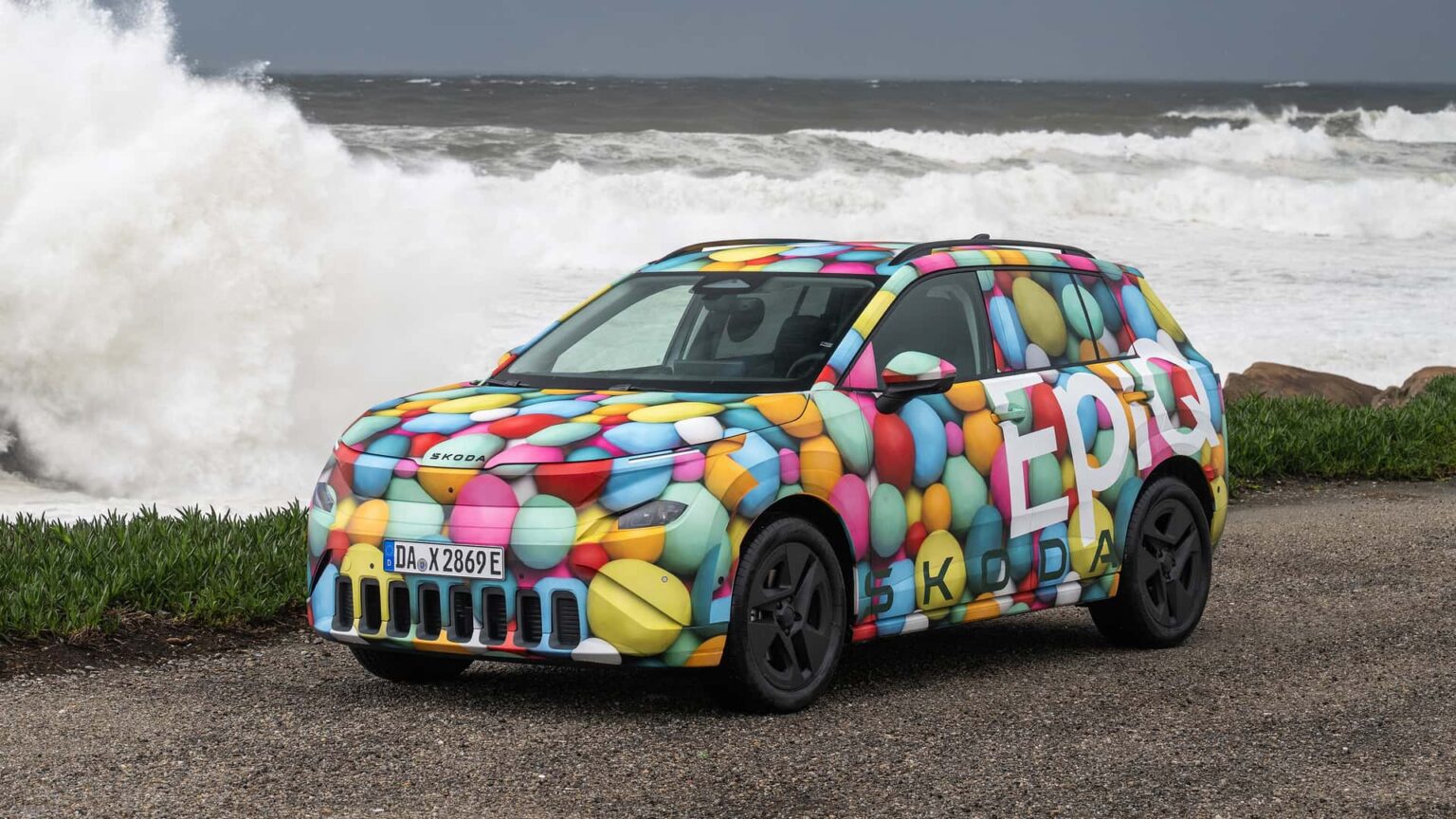Elektrisk bil fra Škoda i farverig camouflage ved havet