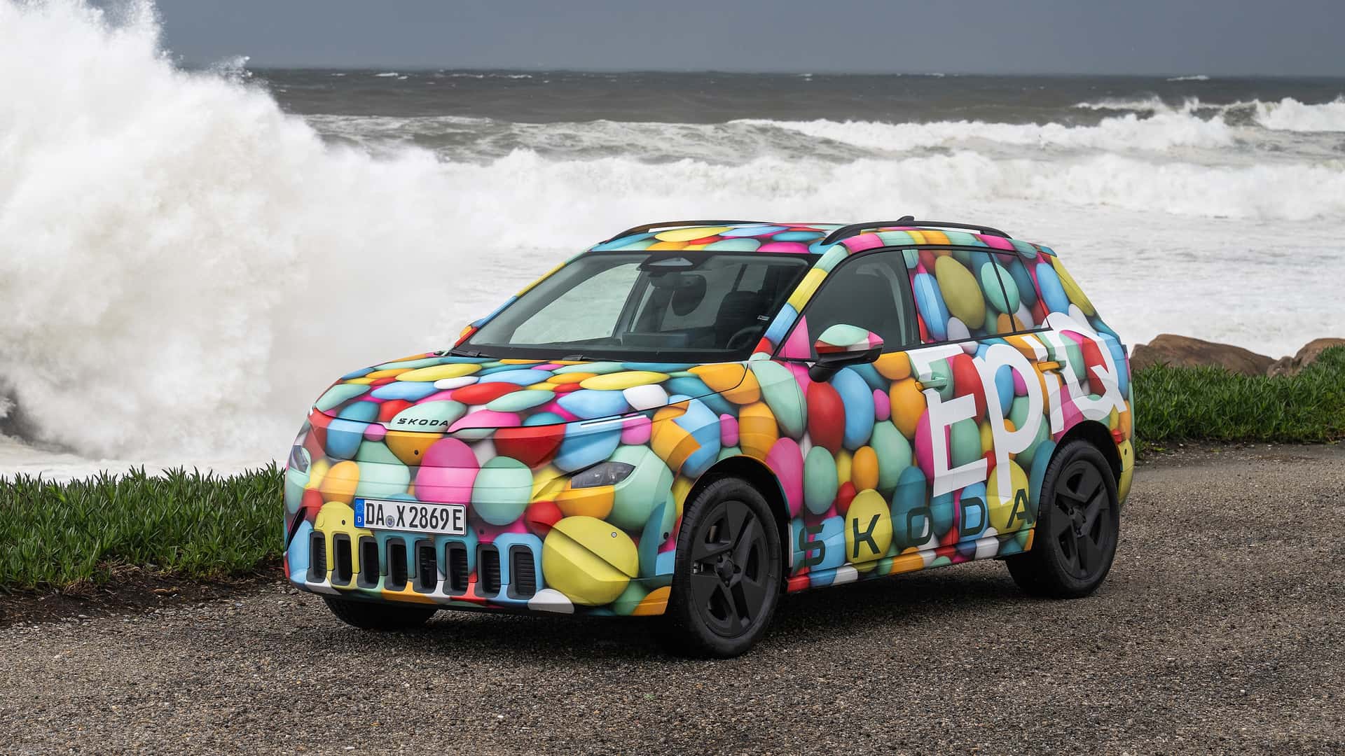 Elektrisk bil fra Škoda i farverig camouflage ved havet