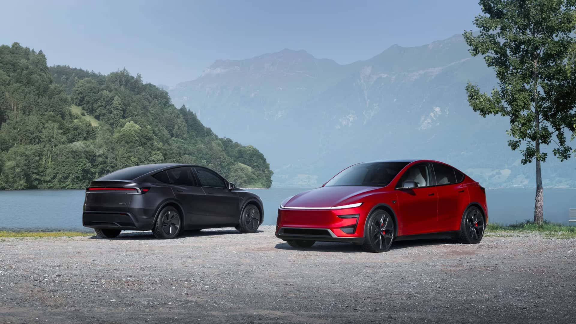 To Tesla-biler parkeret ved en sø med bjerge i baggrunden