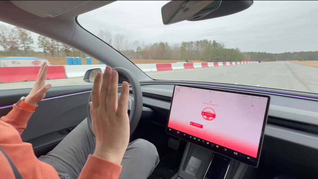 Tesla Model 3 med aktiv autopilot viser advarsel på skærmen for at tage kontrol over bilen.