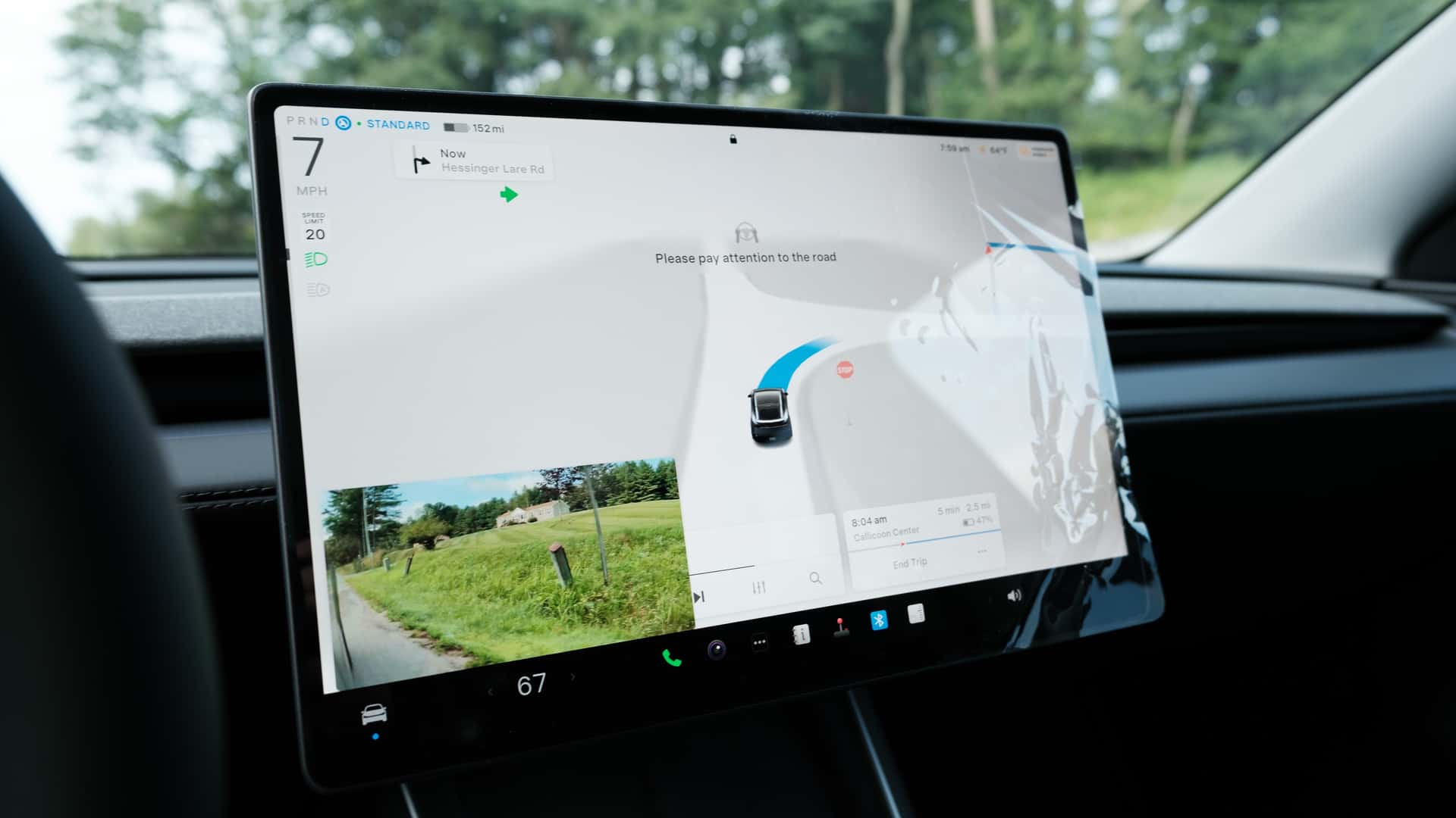 Tesla bilens touchskærm viser navigation og kameravisning under kørsel