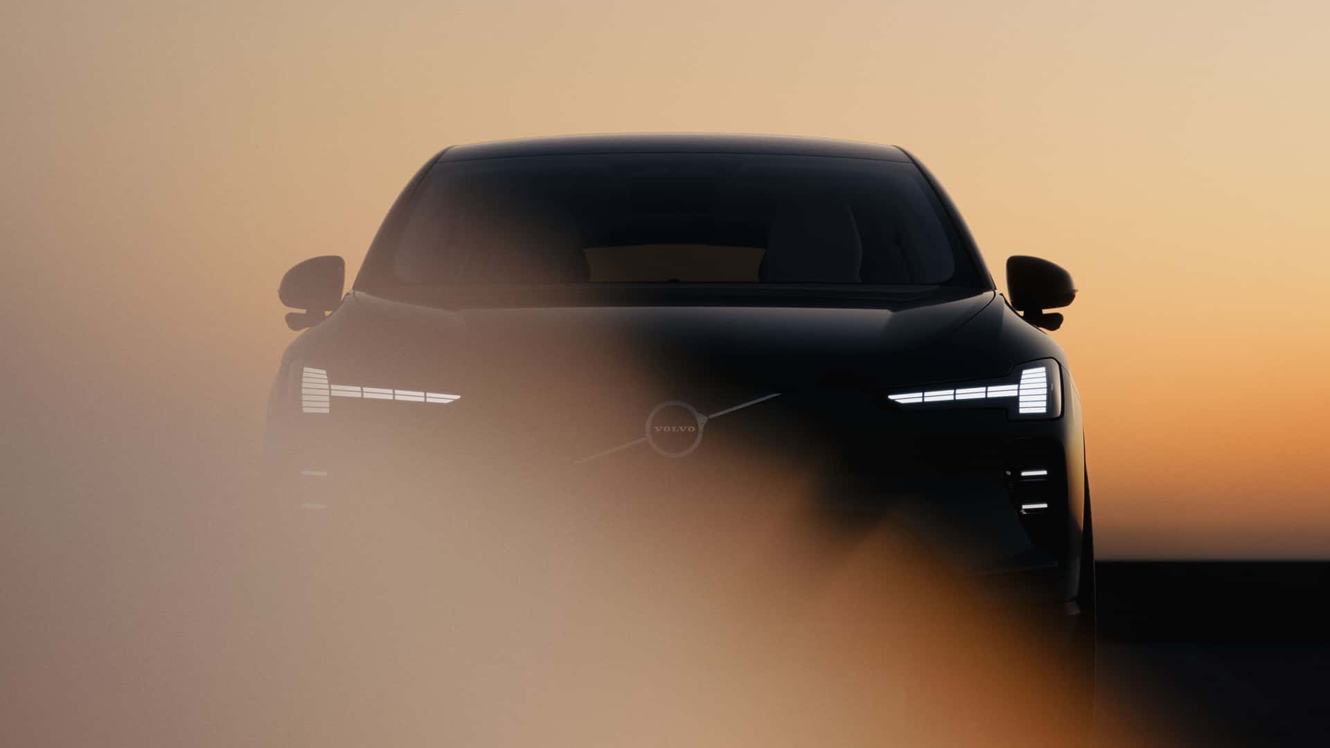 Forlygter på en bil, der kører i tåge ved solnedgang