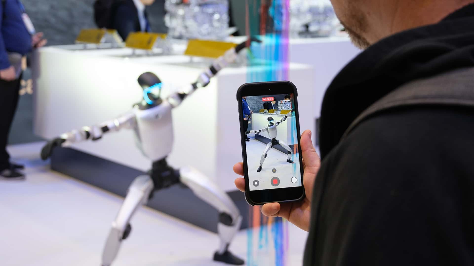 En person optager en avanceret robot med sin smartphone på en teknologimesse