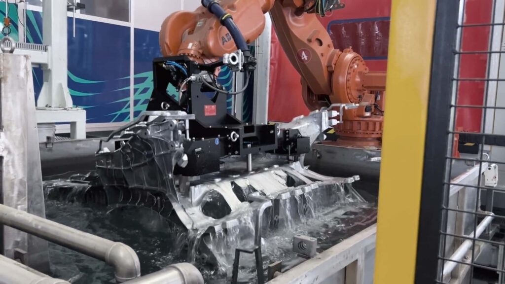 Industrirobot monterer komponent til elbil i produktionslinje