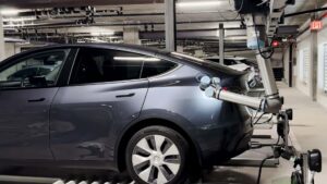 Tesla elbil oplades af automatisk robotarm i parkeringskælder