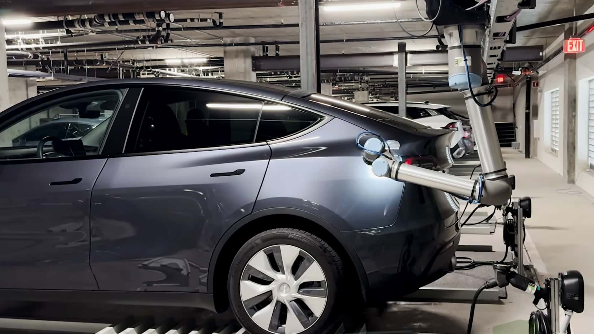 Tesla elbil oplades af automatisk robotarm i parkeringskælder