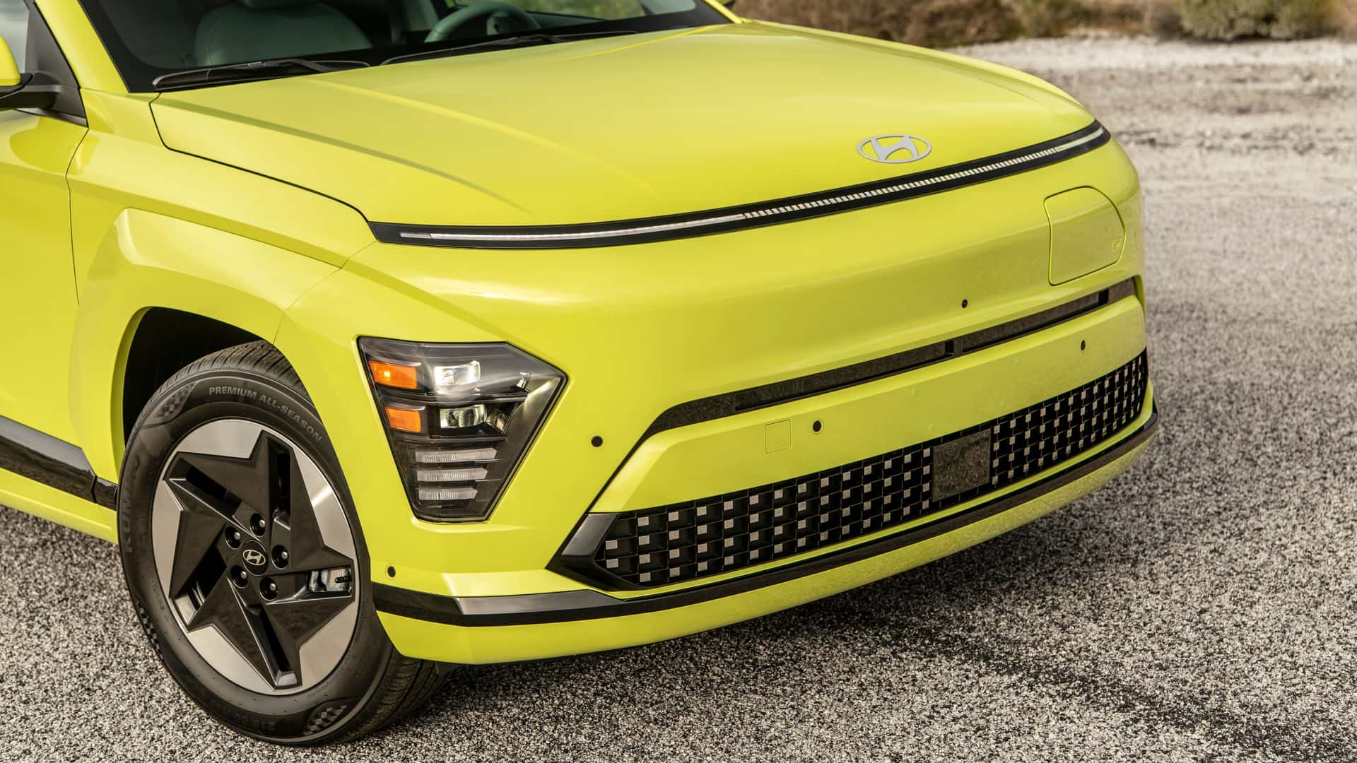 Nærbillede af fronten på en gul elektrisk bil på en grusvej