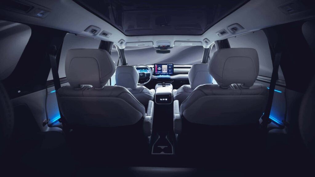 Elegant interiør i en Tesla, set bagfra med moderne skærmbetjening og futuristisk design