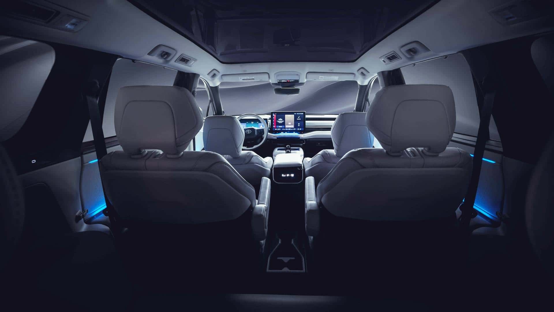 Elegant interiør i en Tesla, set bagfra med moderne skærmbetjening og futuristisk design