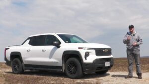Mand står ved siden af en hvid Chevrolet Silverado elektrisk pickup ved en mark