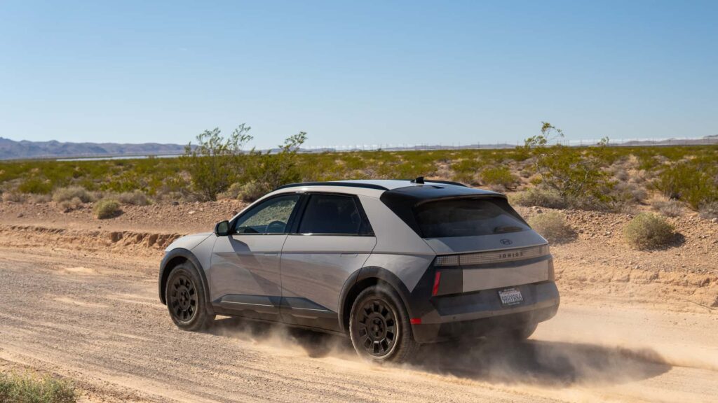 Elektrisk bil kører på grusvej i ørkenlandskab