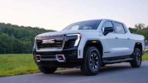 Hvid GMC pickup truck parkeret ved vejkanten med skov i baggrunden