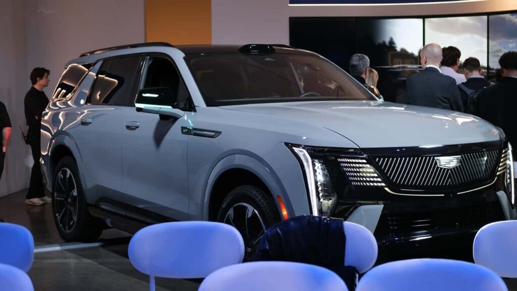 Præsentation af ny elektrisk SUV på teknologiudstilling omgivet af tilskuere