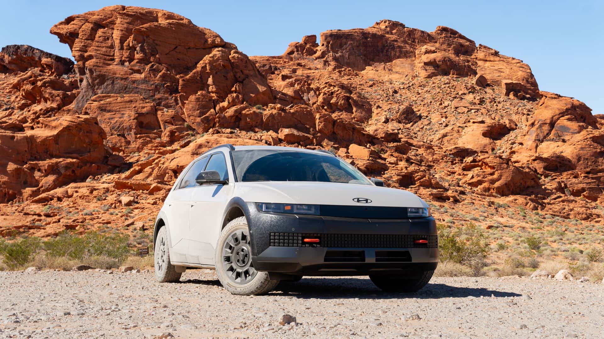 Hyundai elbil parkeret foran røde klipper.